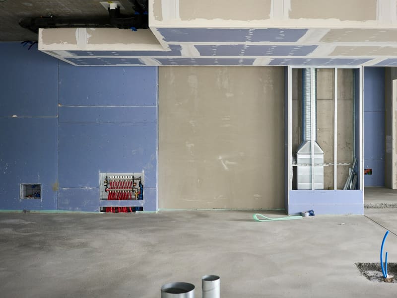 Rohbau-Innenraum mit neuen Trockenbauwänden und abgehängter Decke